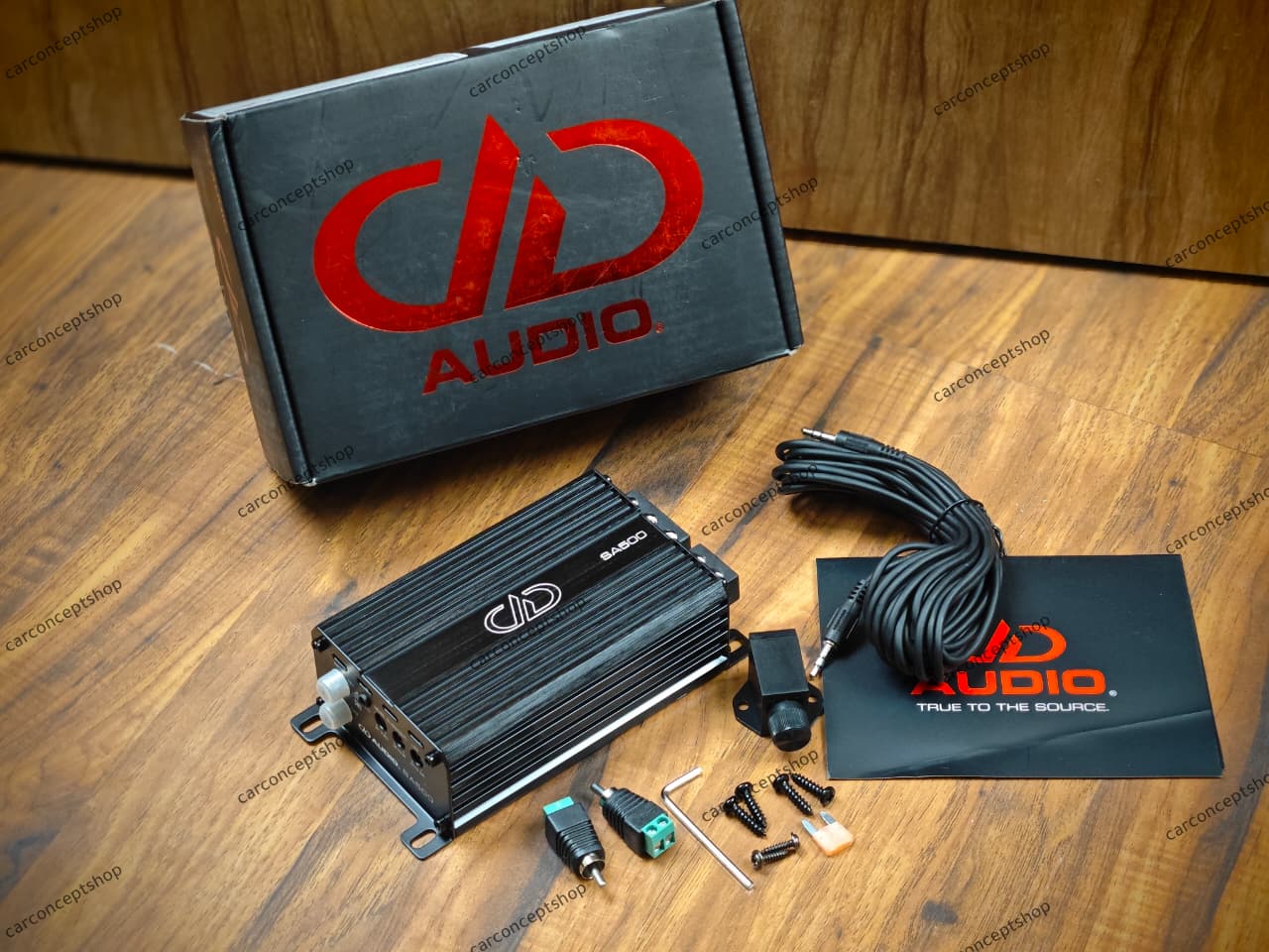 DD Audio RL-SA500.1 compact monoblock amplifier showing the aluminum heatsink, set-screw power terminals, and included remote bass control knob.